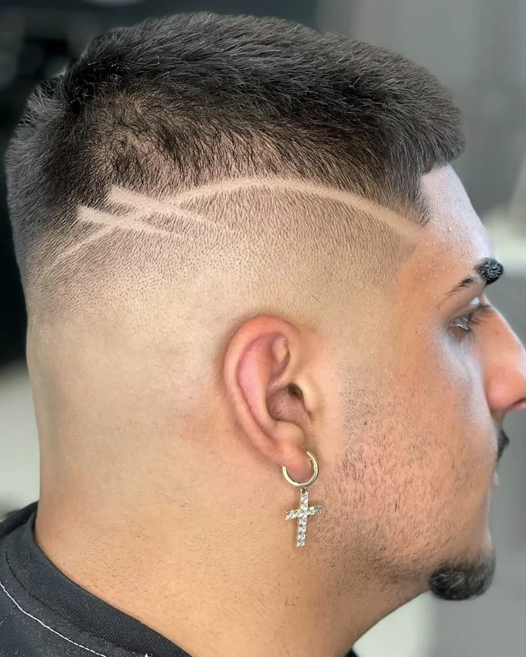 Skin fade with a freehand hair tattoo above the ear